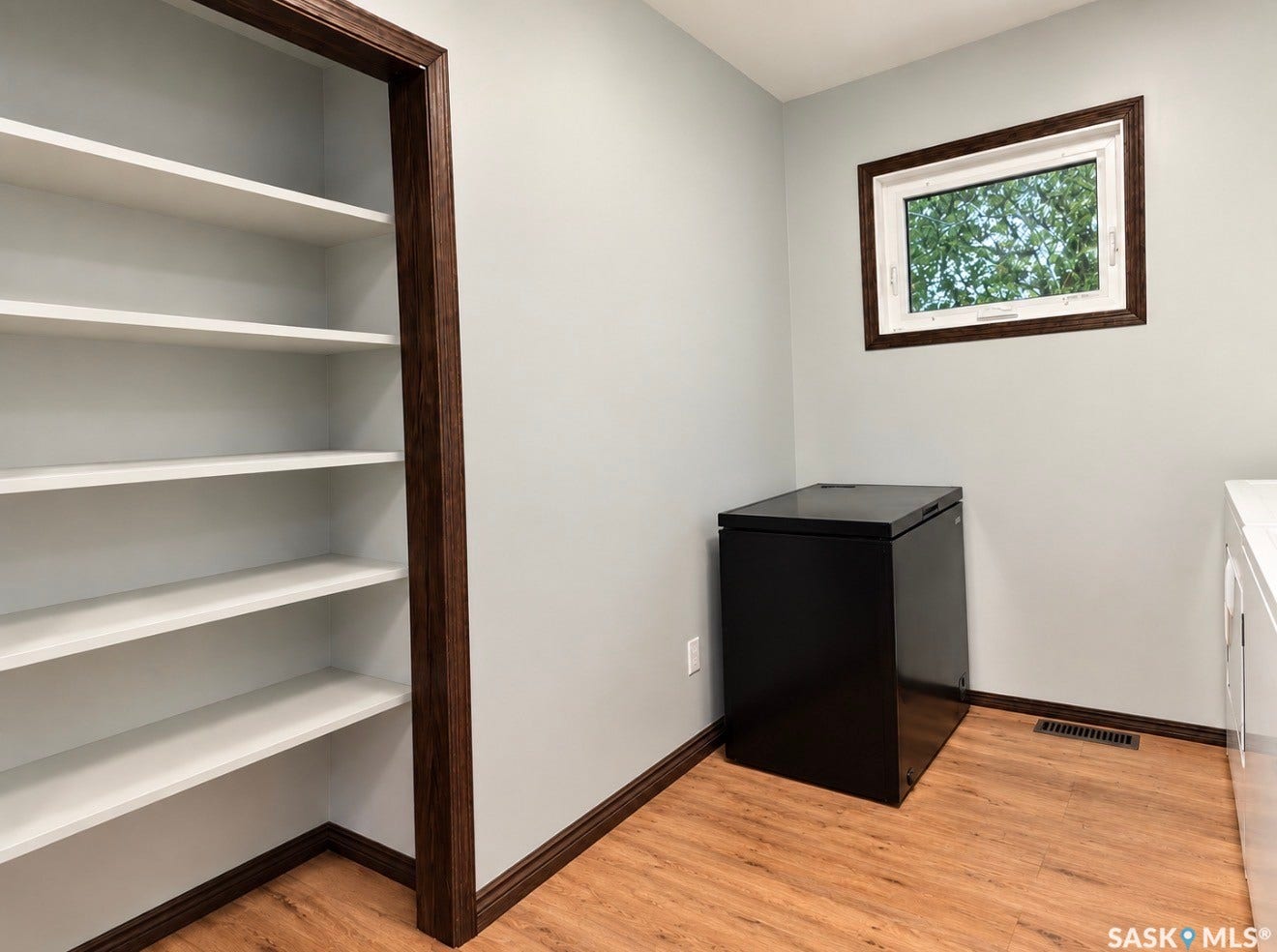 Built-in shelving, wood-finish flooring, and a casement window with dark wood-finish trim