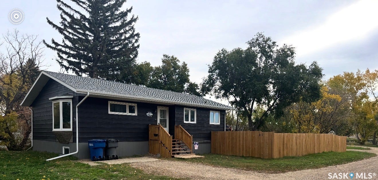 Charcoal gray exterior with a contrasting white trim, featuring a prominent bay window