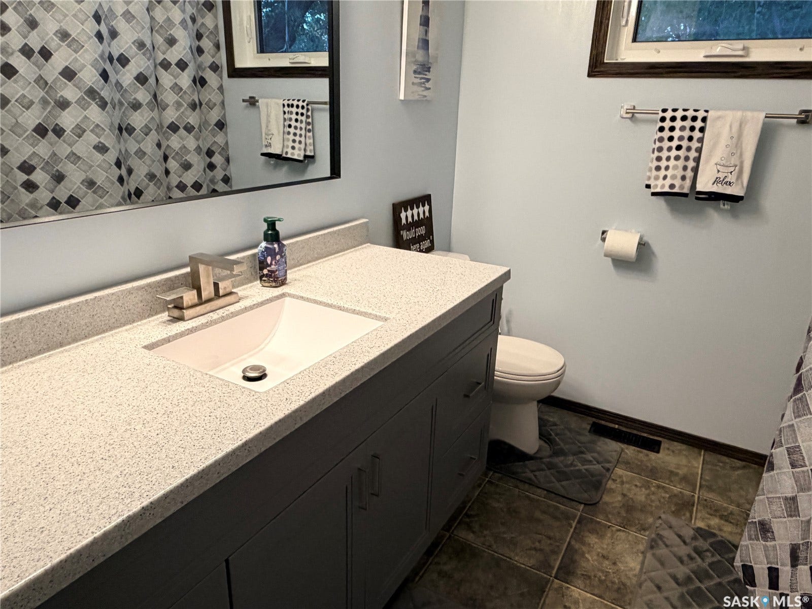 Bathroom vanity with an integrated sink, brushed nickel faucet, and under-sink cabinetry
