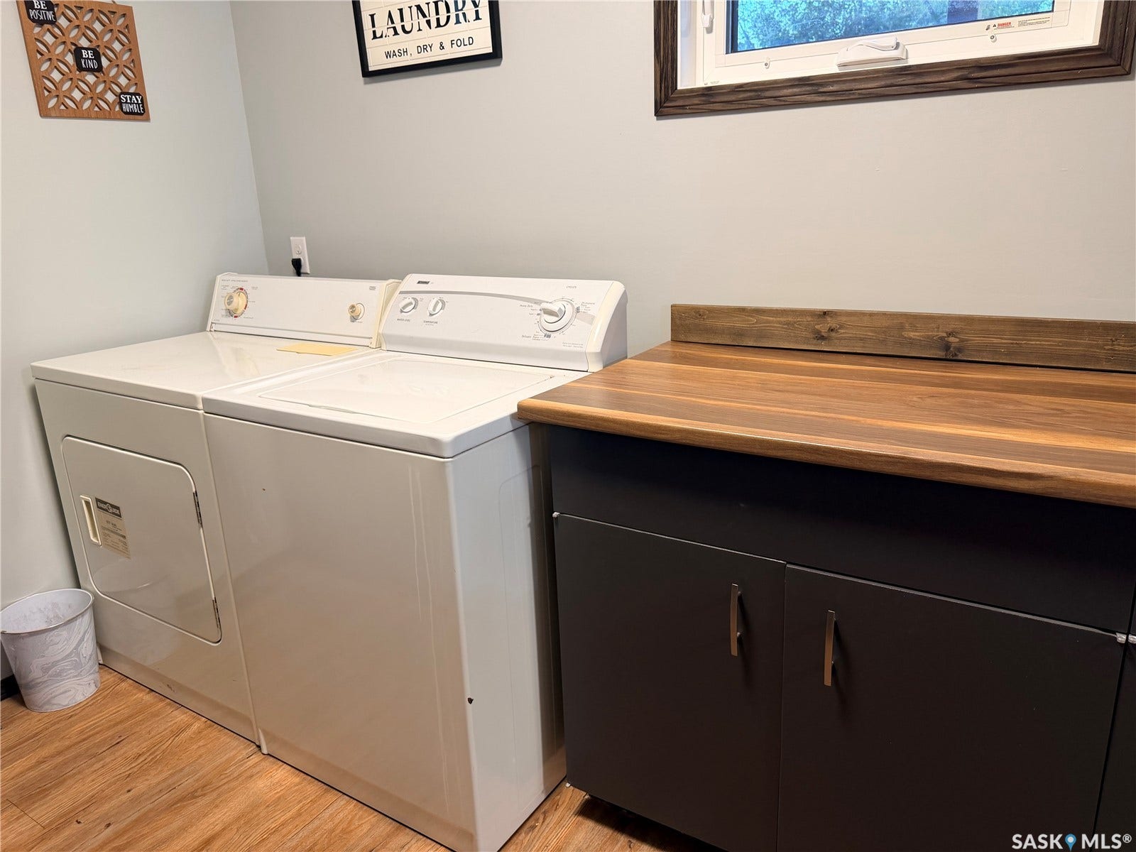 Wood-finish flooring, built-in cabinetry with modern hardware, and a wood-finish countertop