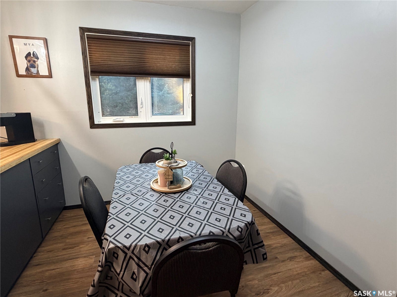 Wood-finish flooring with white walls and a window featuring a pleated shade