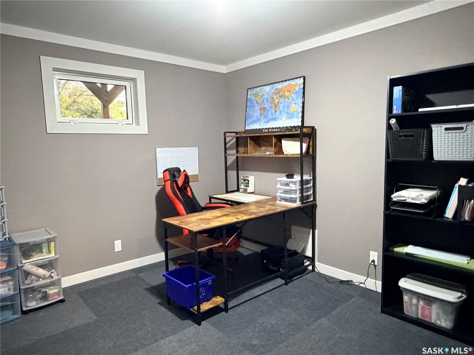 Recessed window with white trim, light gray painted walls, dark gray carpeted flooring, and white crown molding