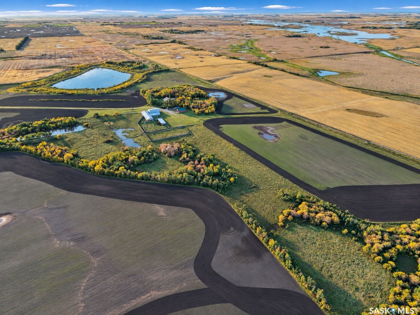 Expansive agricultural landscape featuring cultivated fields and natural water bodies