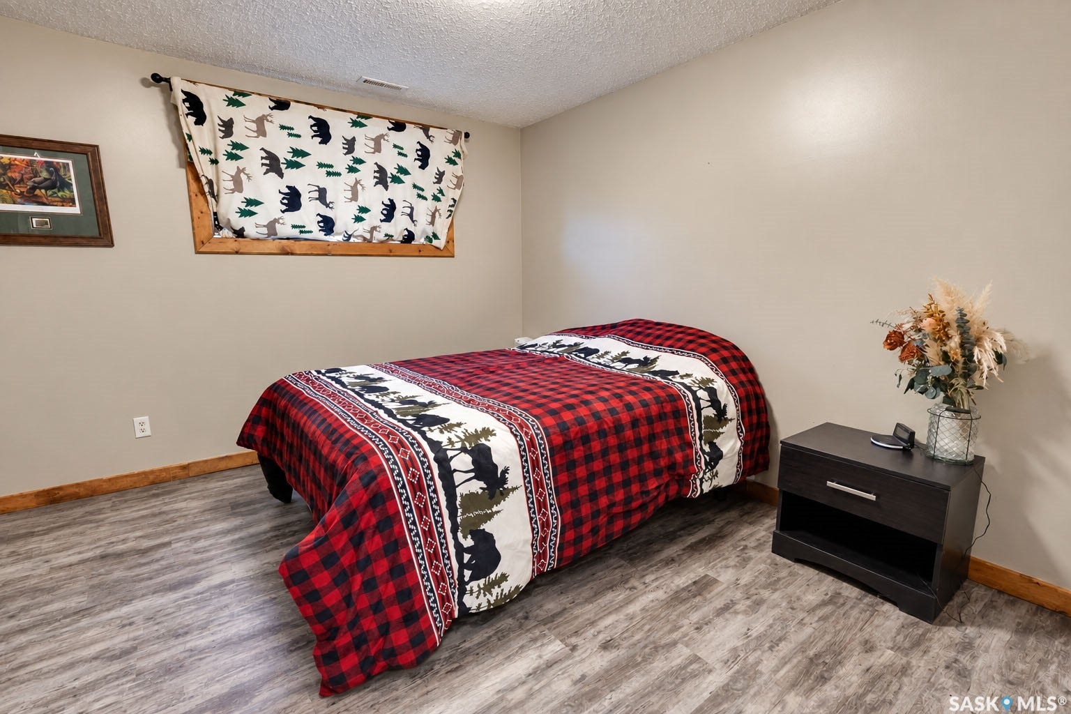 Wood-finish flooring with coordinating wood trim, neutral wall paint, and a built-in window with wood framing