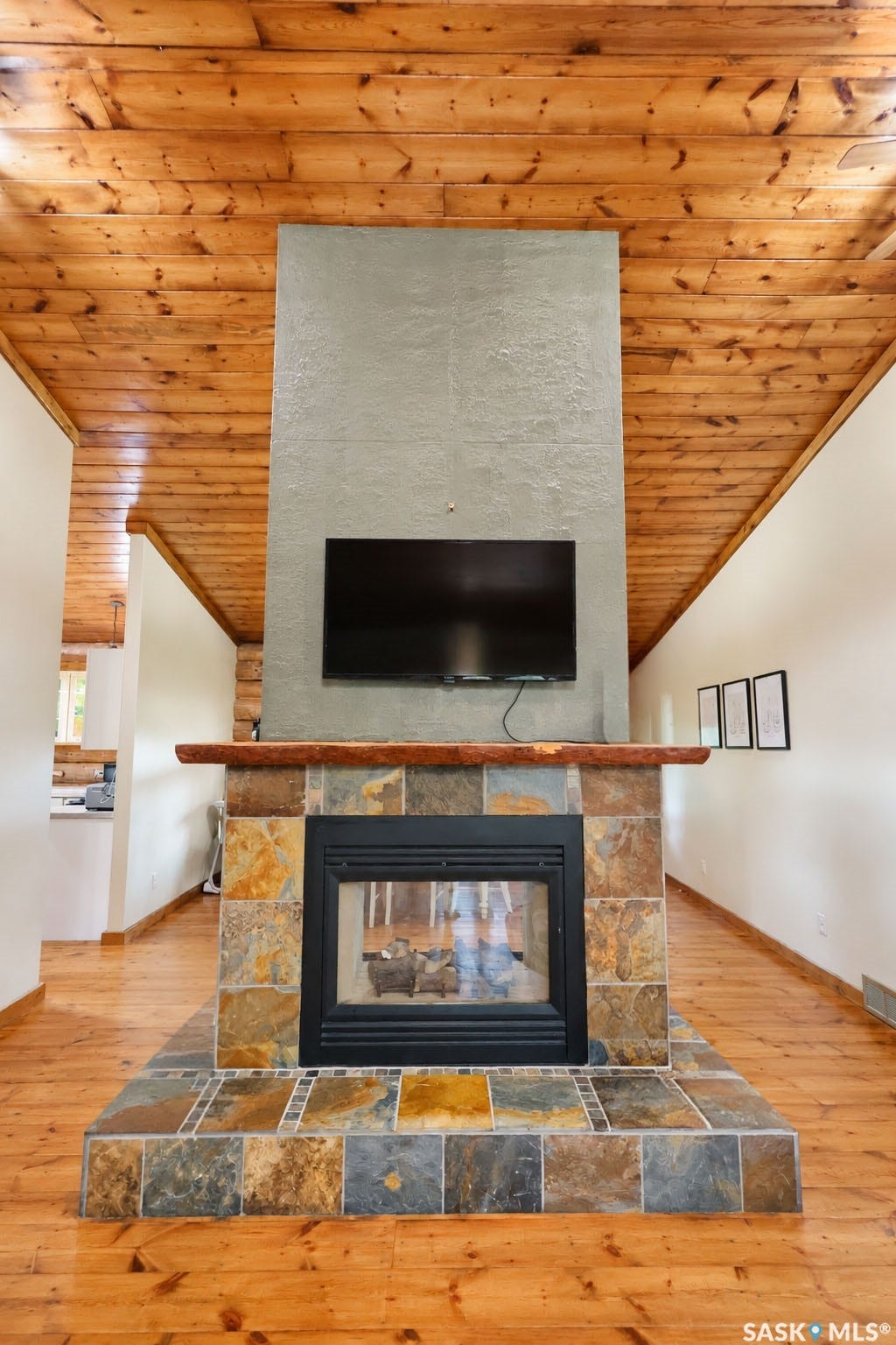 Wood-finish flooring and ceiling, stone-clad fireplace, and an integrated firebox