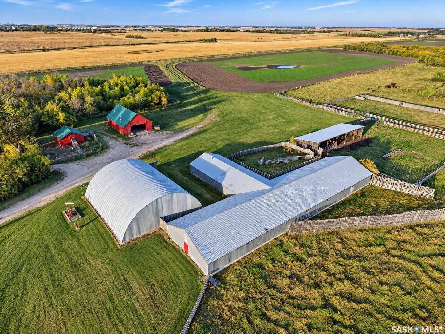 Expansive rural property featuring multiple outbuildings, fenced enclosures, and agricultural fields