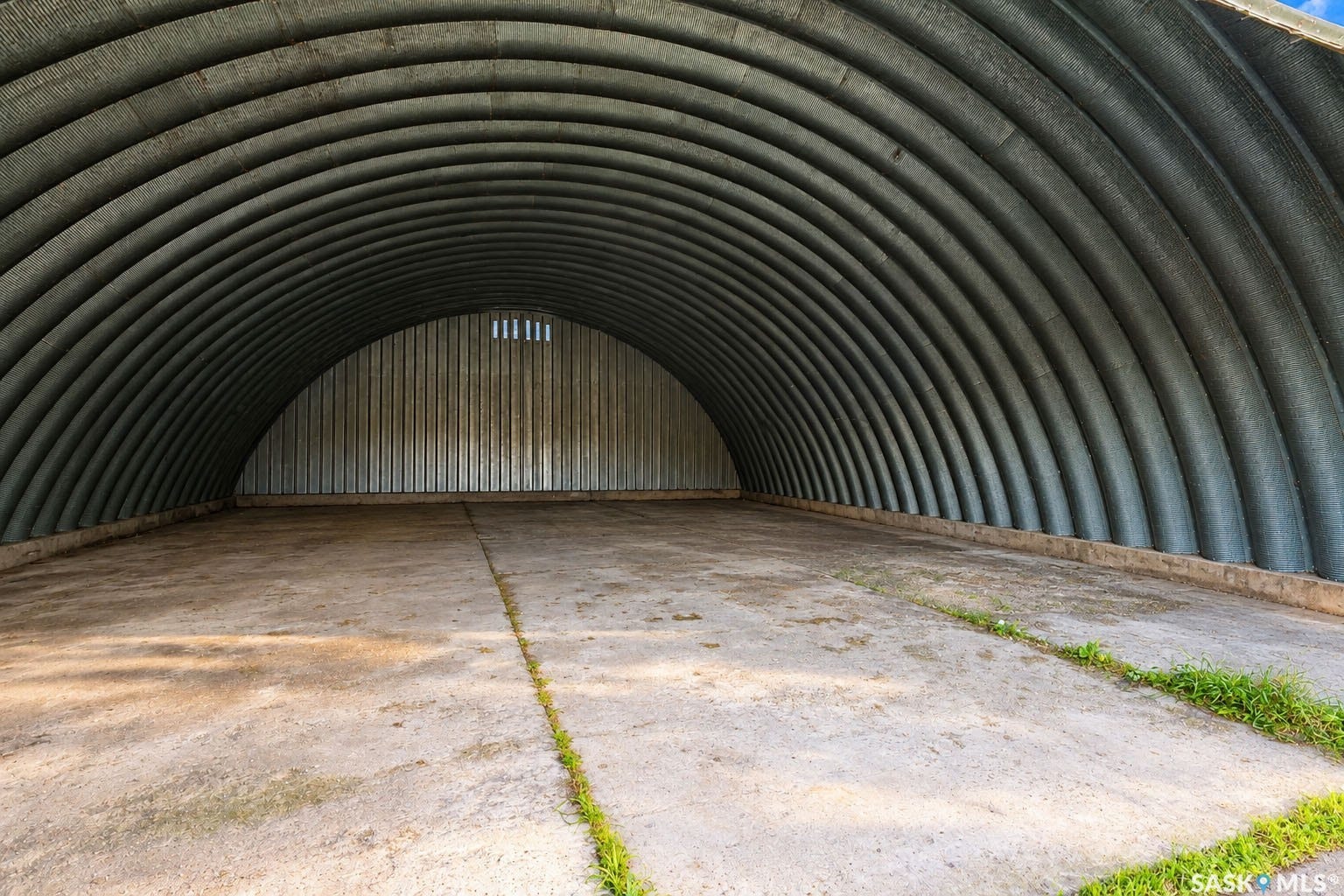 Corrugated metal archway structure with a concrete floor