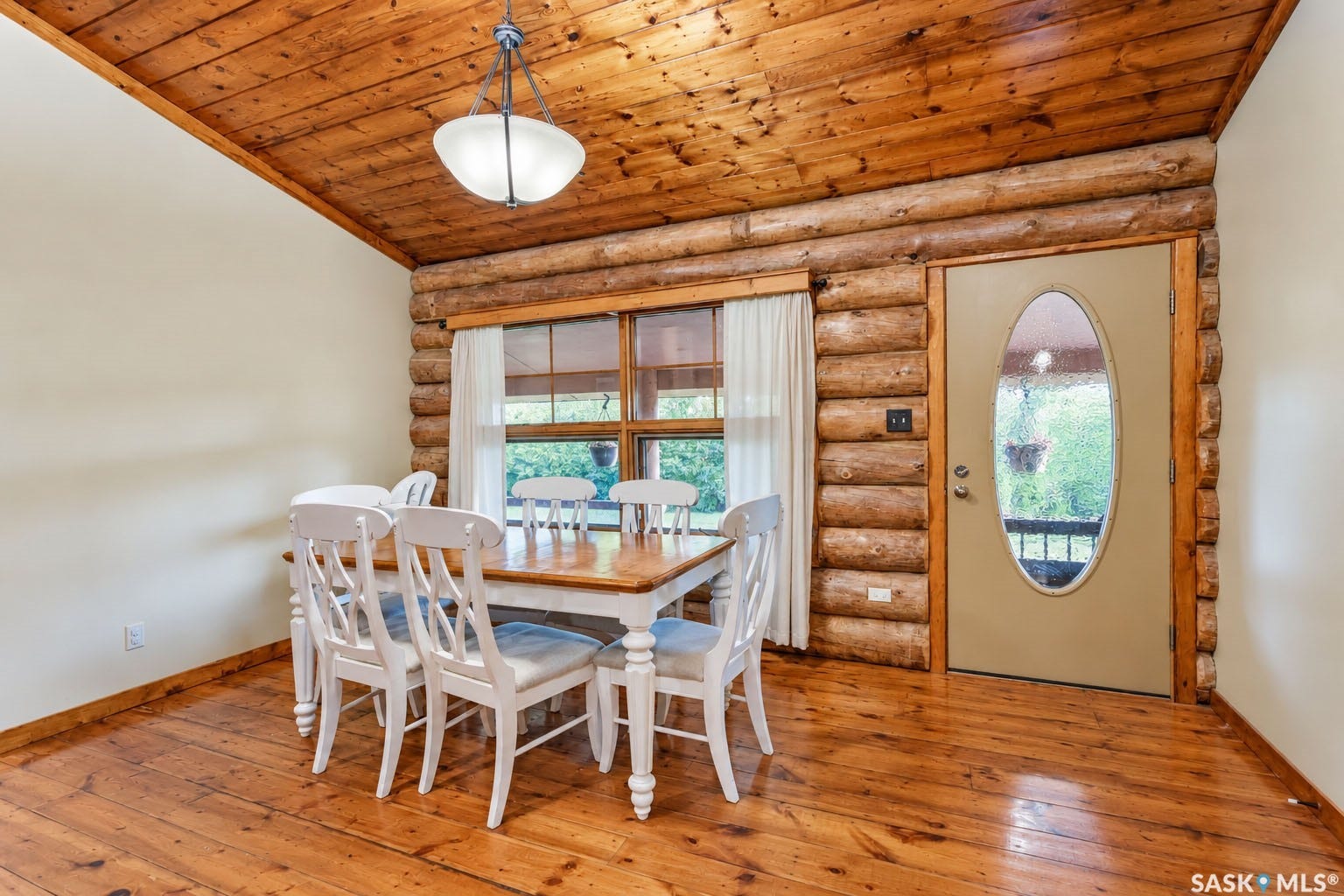 Wood-plank flooring, wood-paneled ceiling, wood-log wall construction, and a window with wood trim
