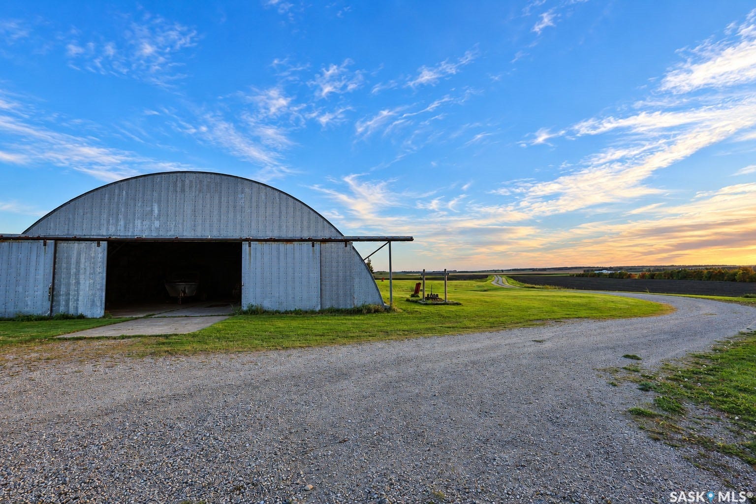 Quonset hut structure with corrugated metal siding, large sliding doors, and a concrete apron