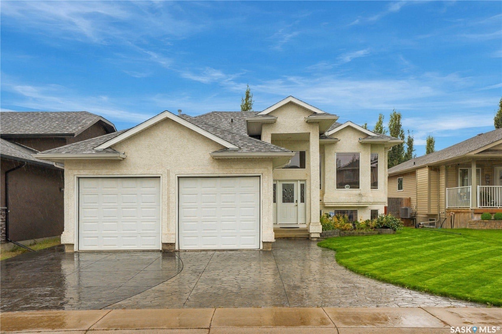 Stucco exterior, double garage, stamped concrete driveway, bay window, and manicured lawn