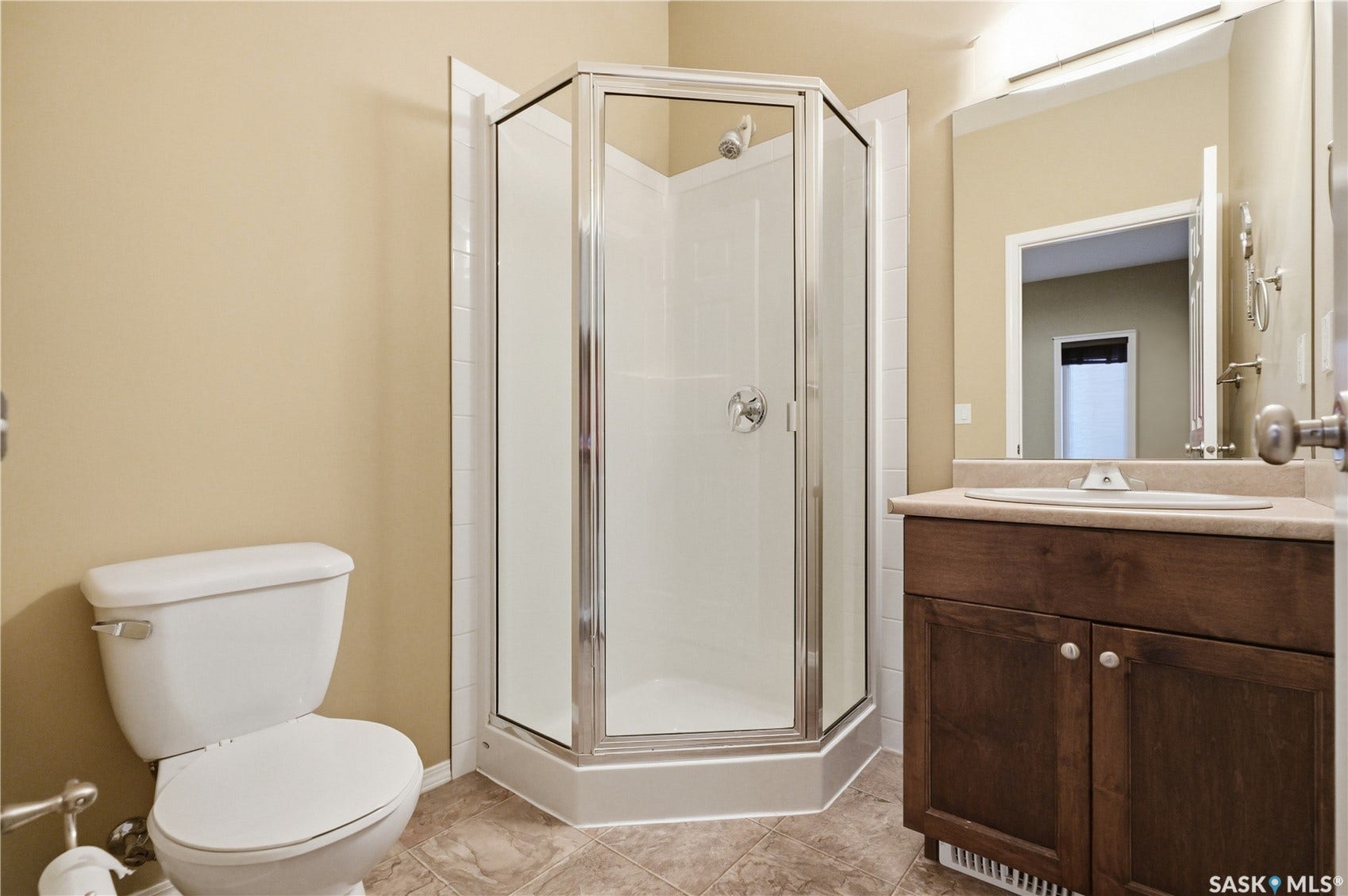 Corner glass-enclosed shower with chrome fixtures