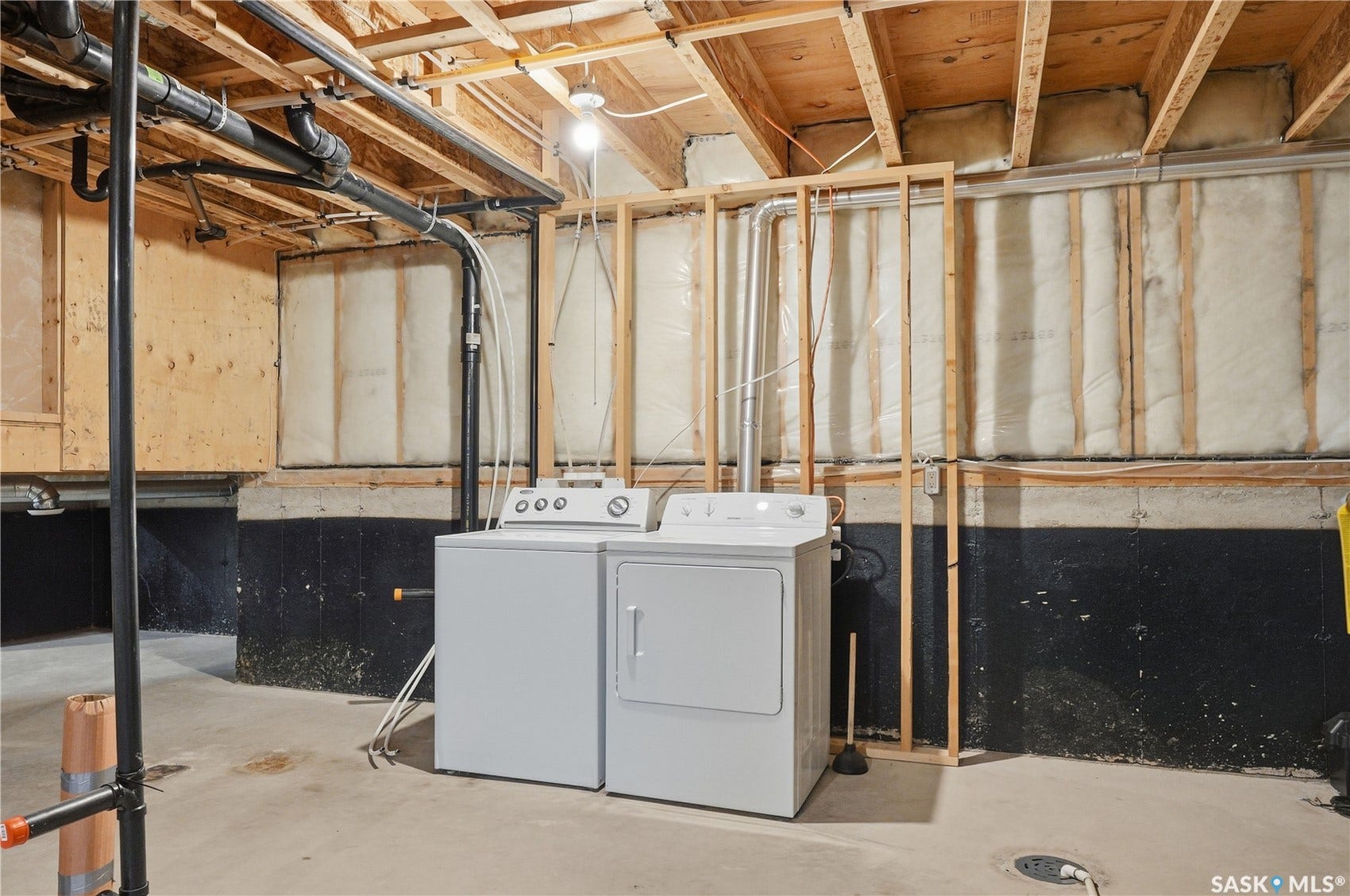 Concrete flooring with exposed ceiling joists and plumbing