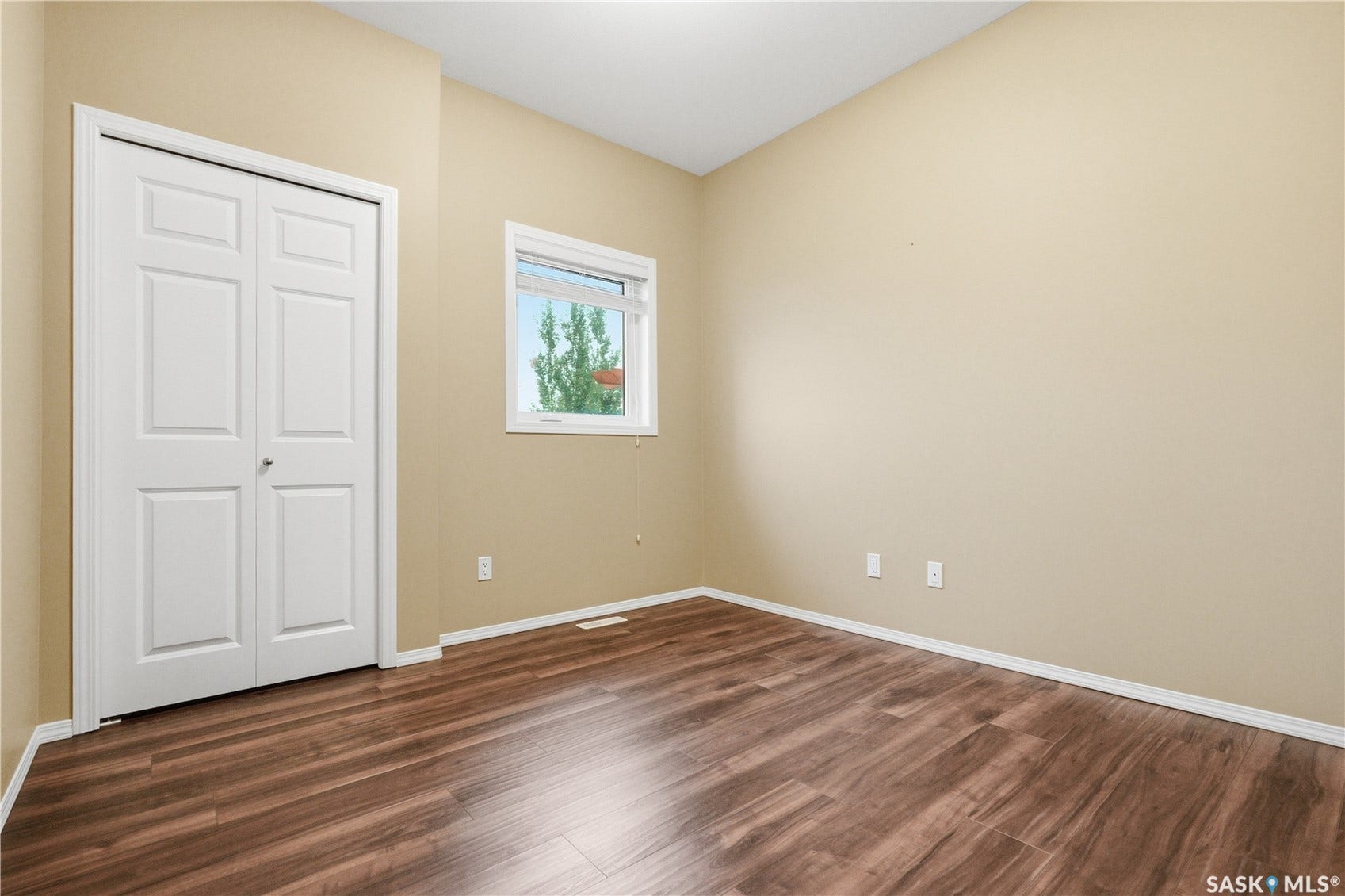 Wood-finish flooring, neutral wall paint, and a white-framed window