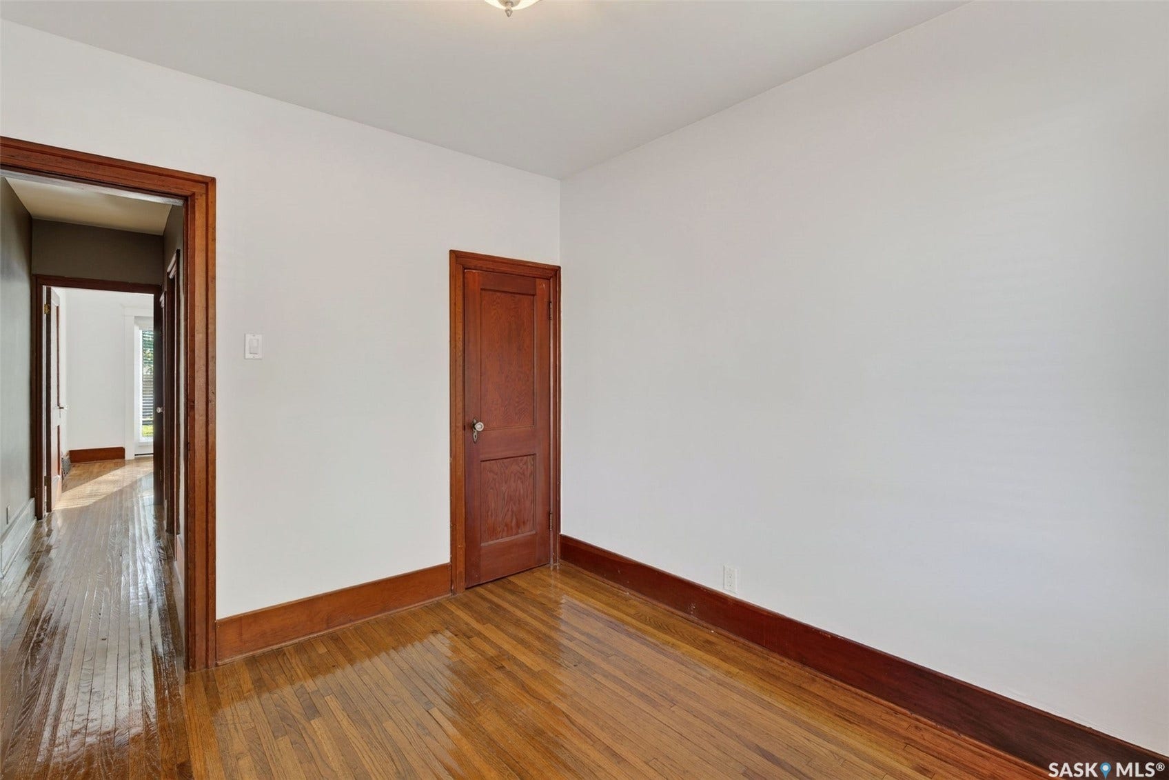 Hardwood flooring throughout, white painted walls, and wood trim details