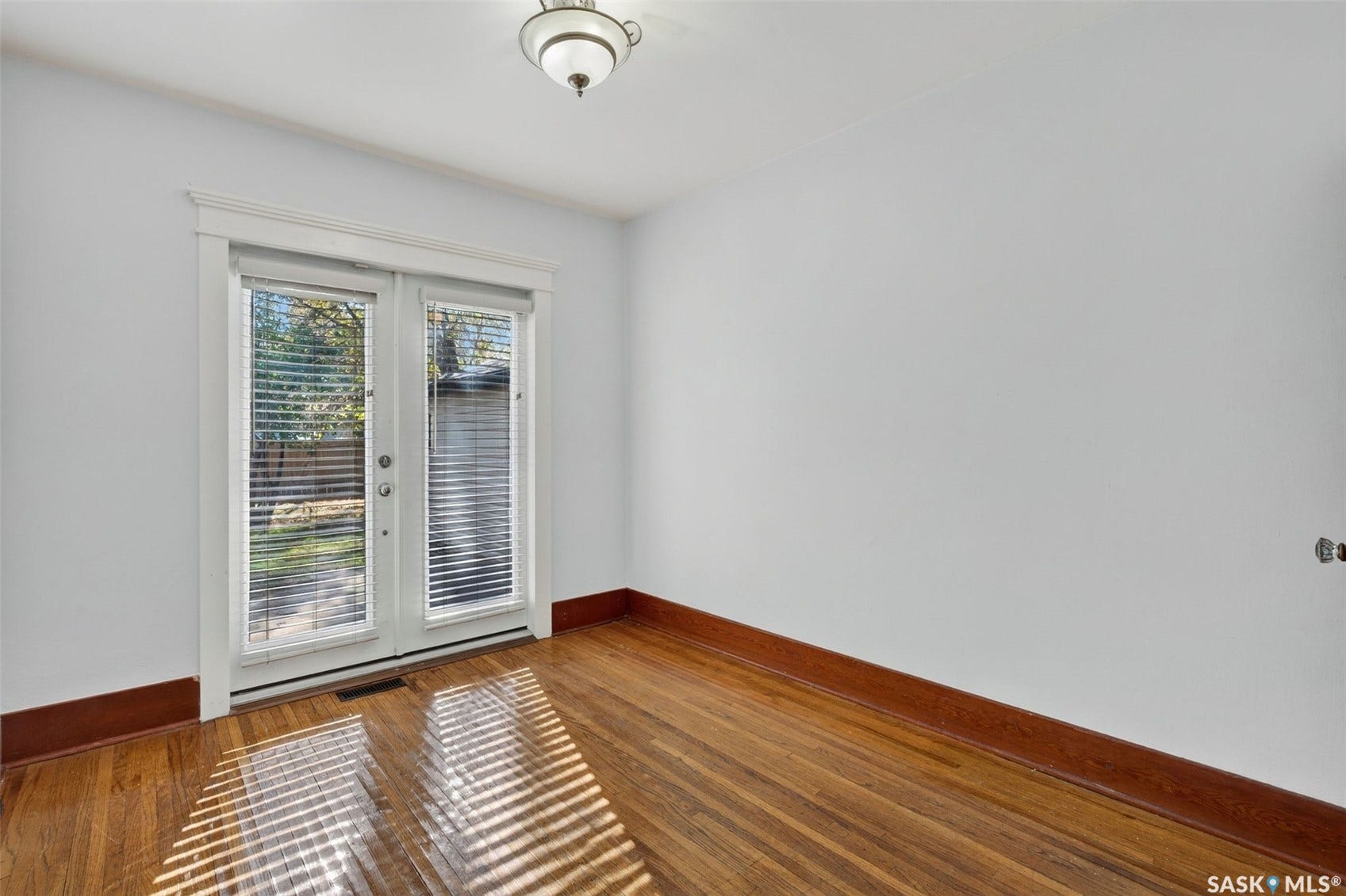 Wood-finish flooring, white walls, and white trim create a neutral palette