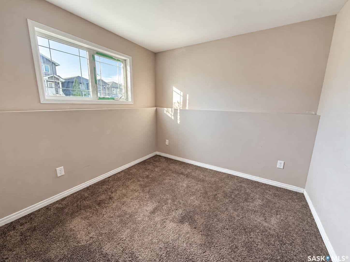 Wall-to-wall carpeting with white baseboards and neutral wall tones