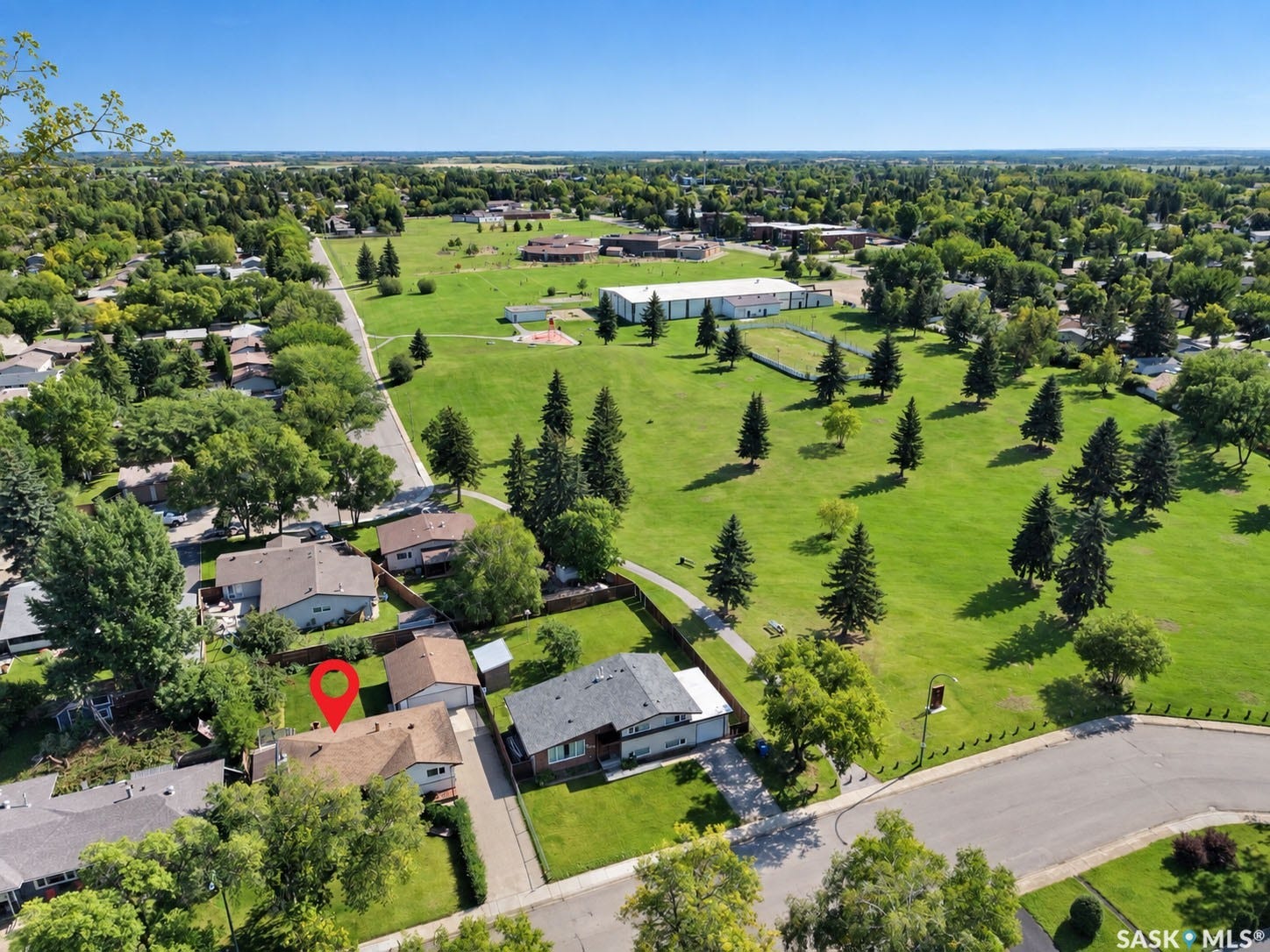 Expansive green spaces and mature trees surround the property