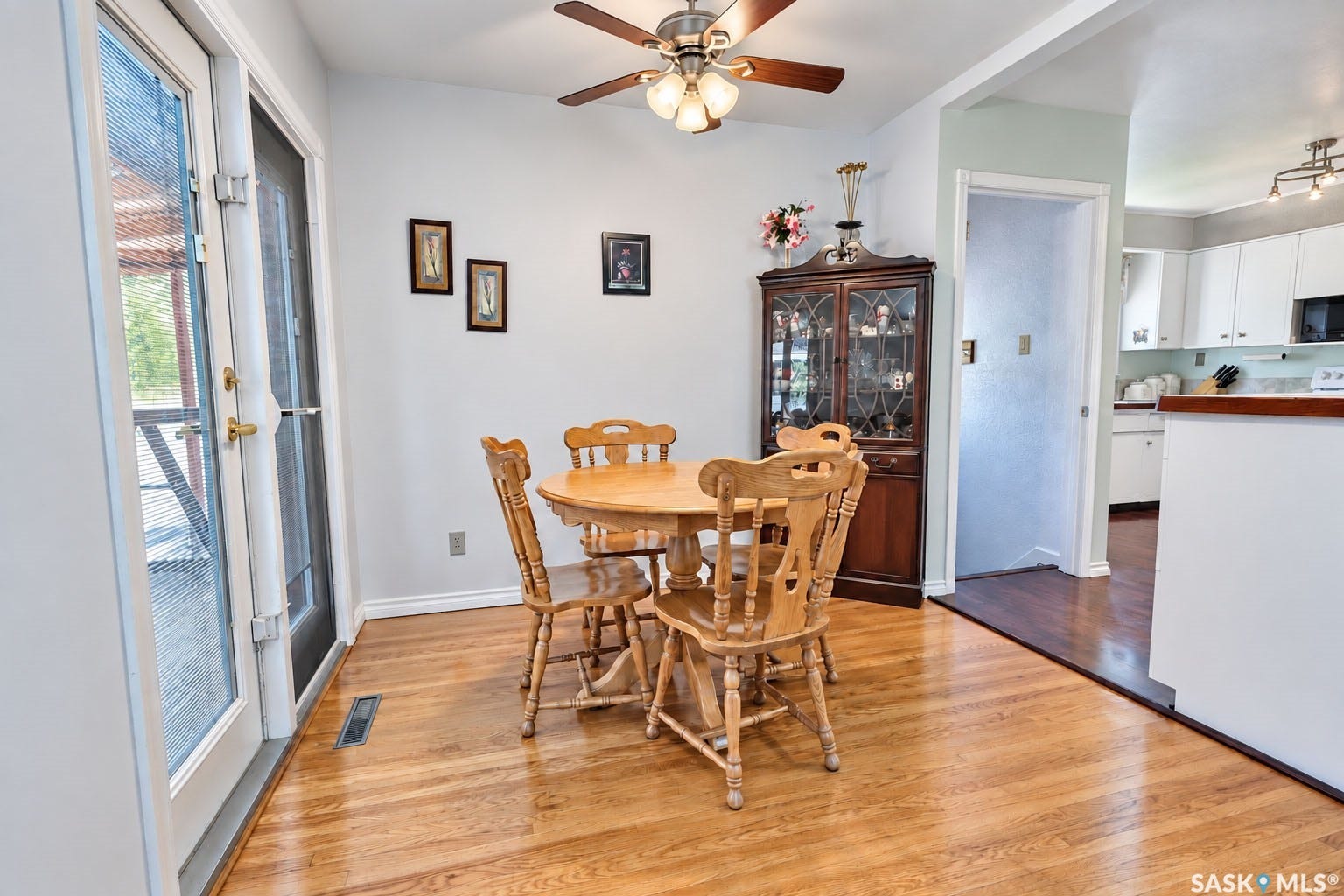 Hardwood flooring throughout, with a ceiling fan light fixture, and double glass doors