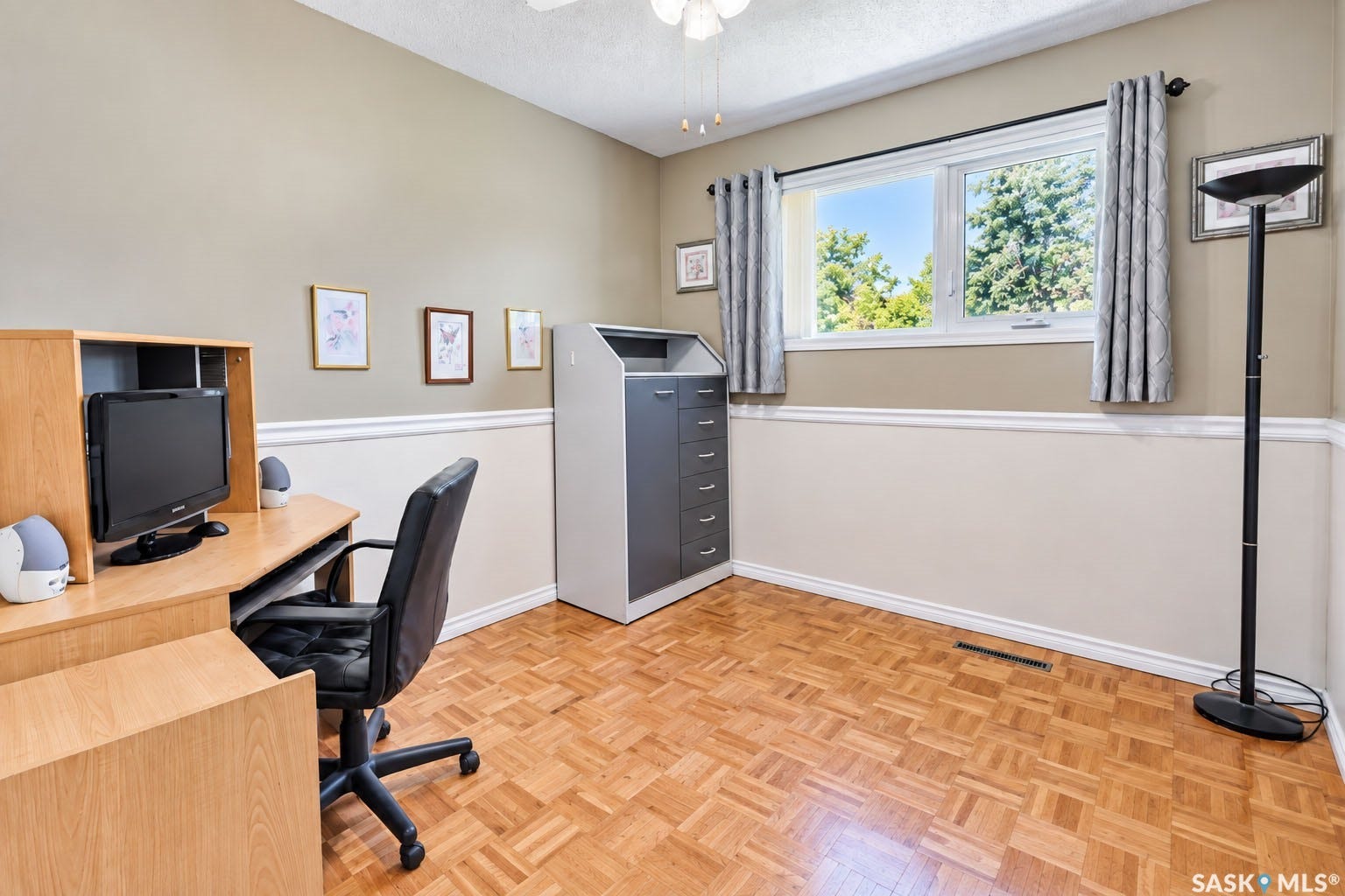 Parquet wood-finish flooring, white trim, and a window with natural light