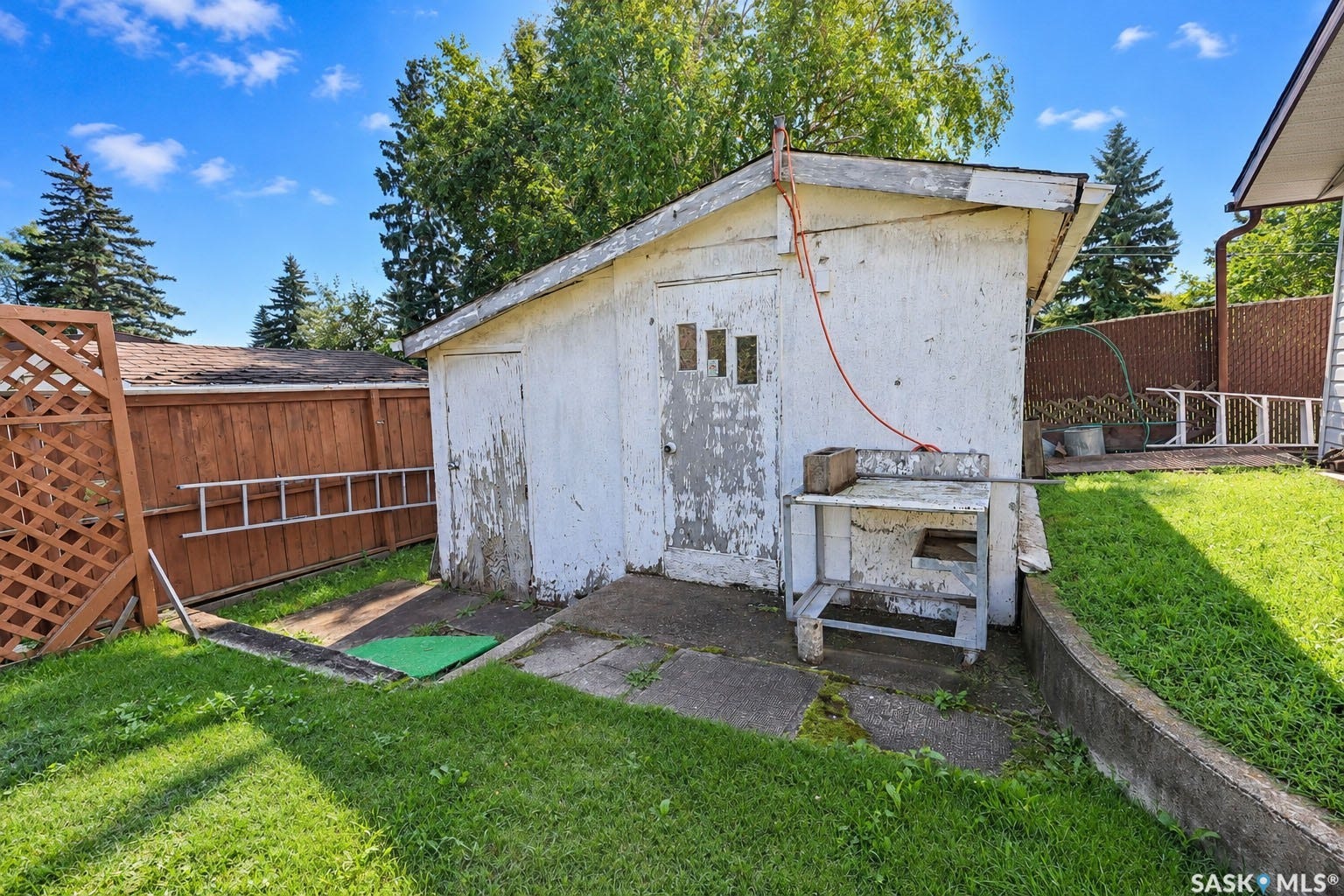 Expansive backyard with a wooden fence and a storage shed
