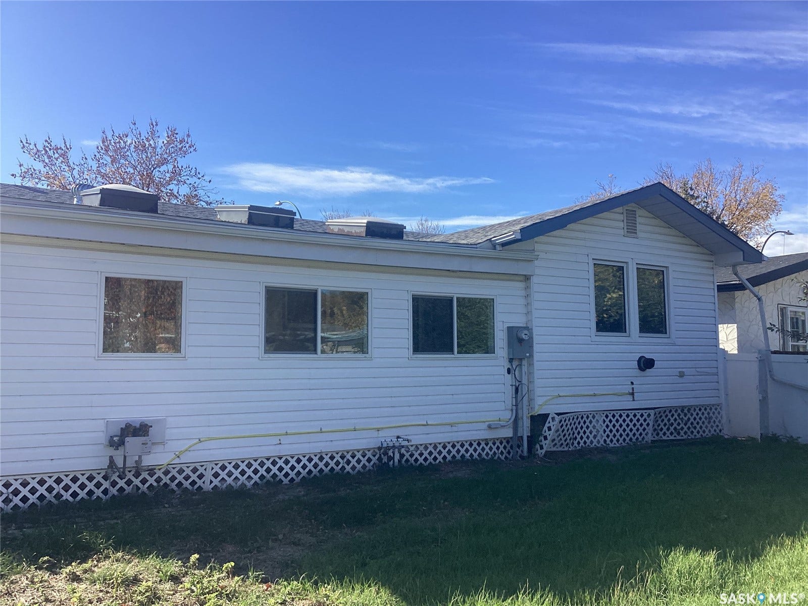 White horizontal siding with multiple windows and a lattice skirting