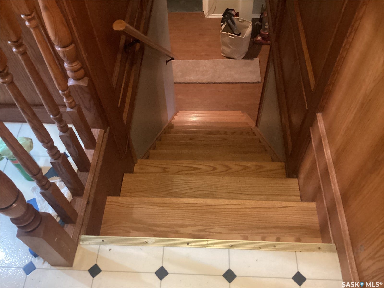 Hardwood staircase with turned wood balusters, wood handrail, and wainscoting