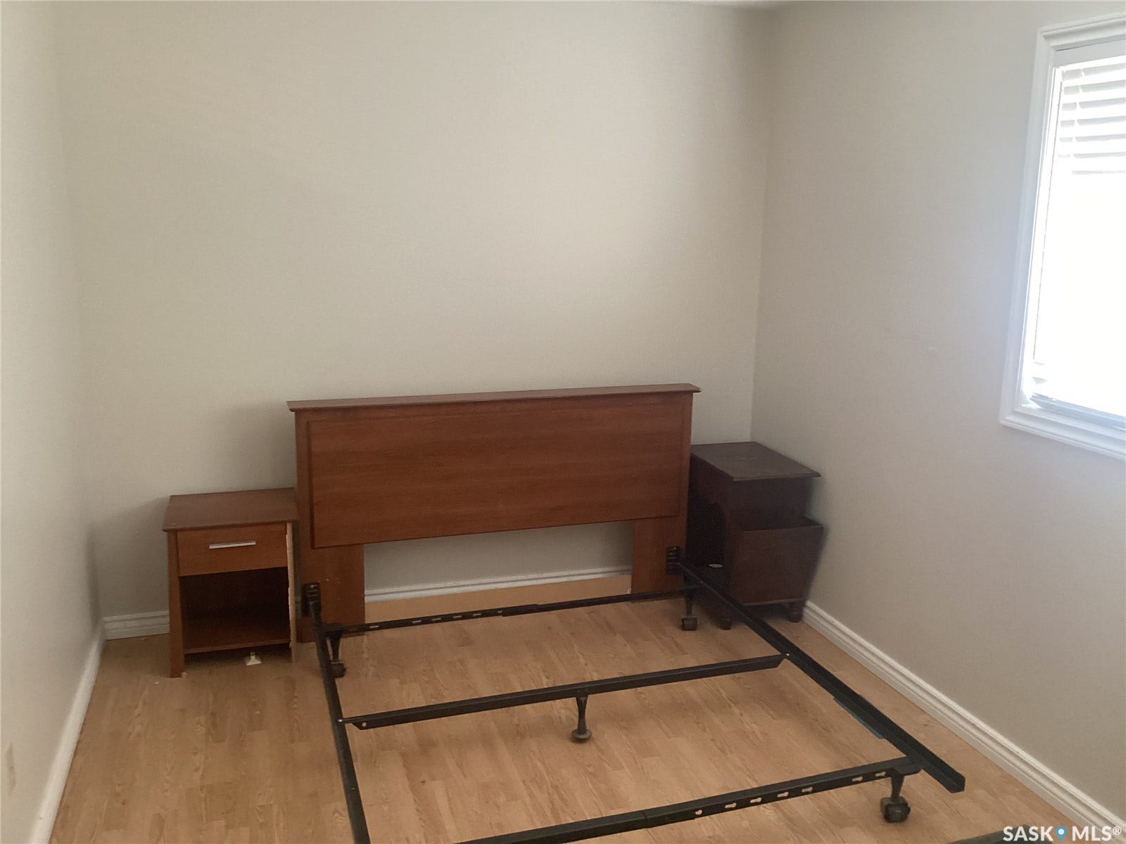 Wood-finish flooring with white baseboards and neutral wall tones