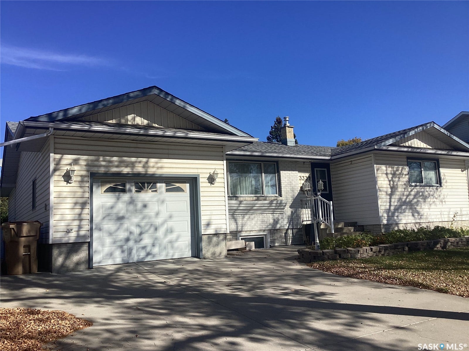 Exterior featuring light-colored siding, an attached single-car garage, and a concrete driveway