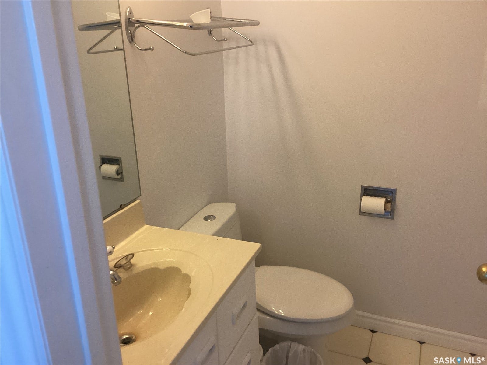 Vanity with built-in sink, wall-mounted mirror, and tile flooring