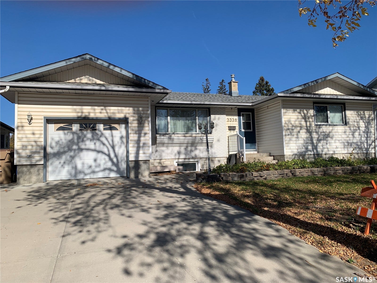 Siding exterior with an attached garage, paved driveway, and front entryway with a porch