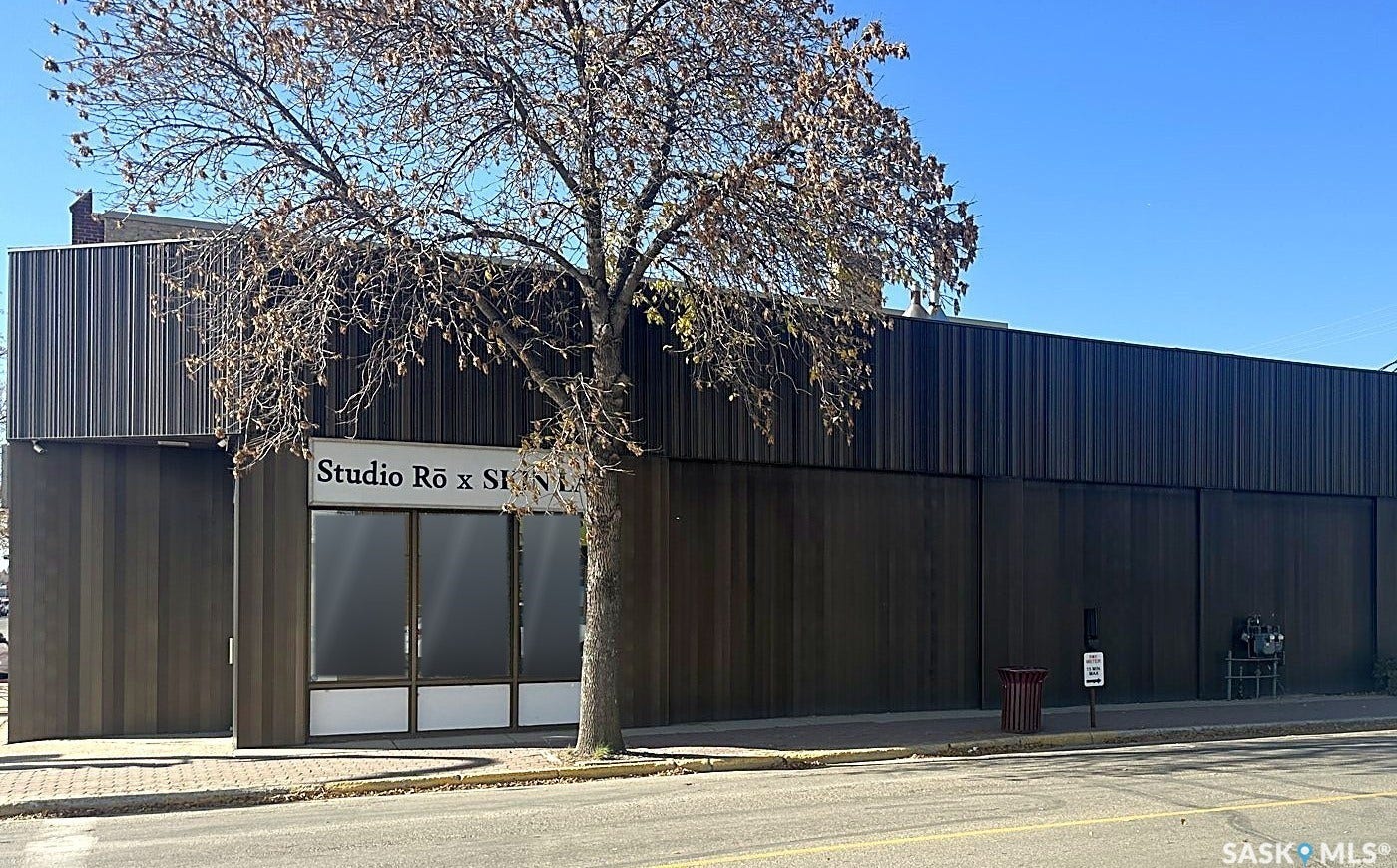Commercial storefront with large display windows, a dark wood-finish facade, and a vertically-paneled upper section