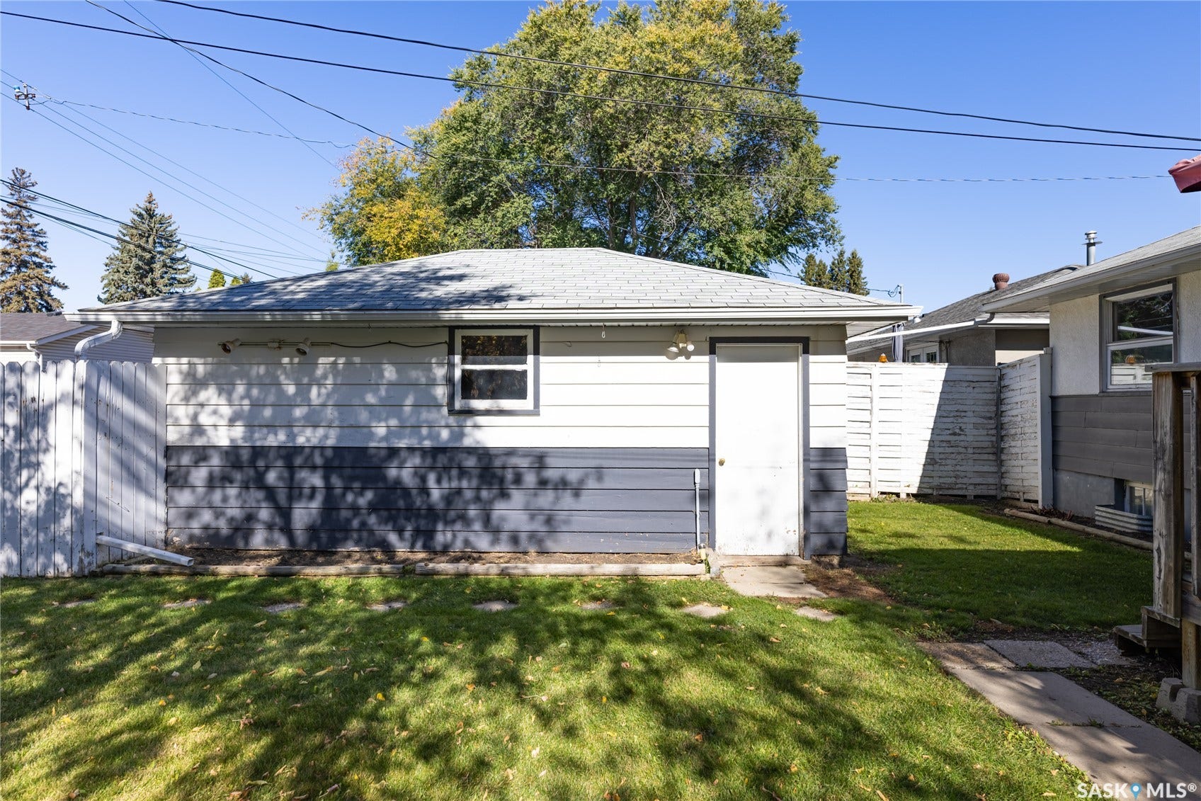 Detached garage with siding exterior and a separate entry door