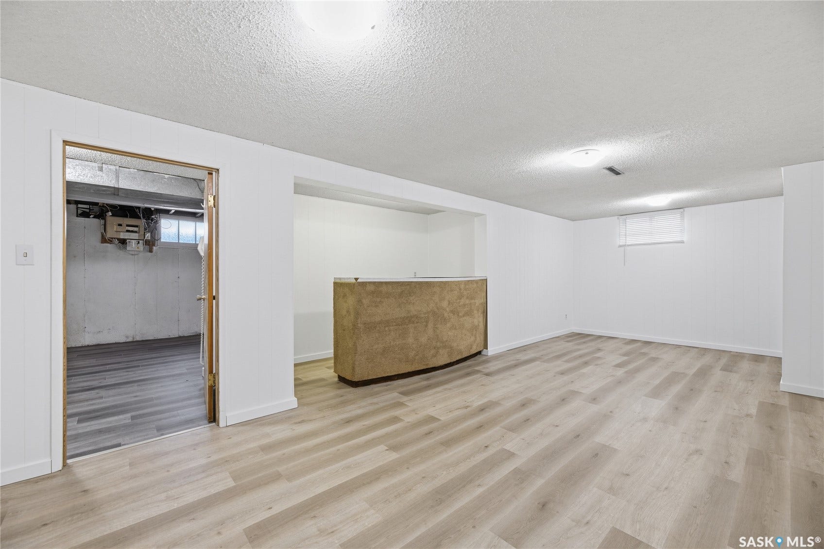 Spacious lower level with wood-finish flooring, recessed lighting, and a built-in bar