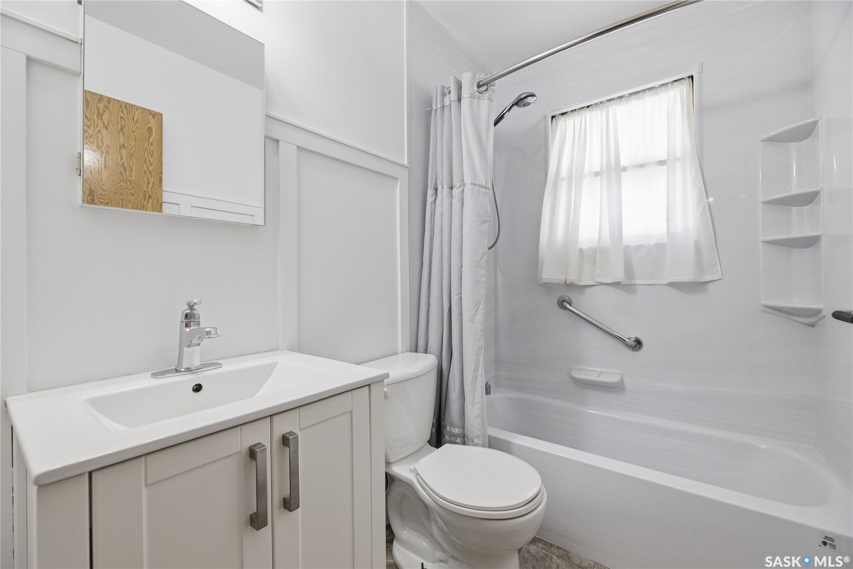 White vanity with chrome hardware, integrated sink, and wall-mounted medicine cabinet