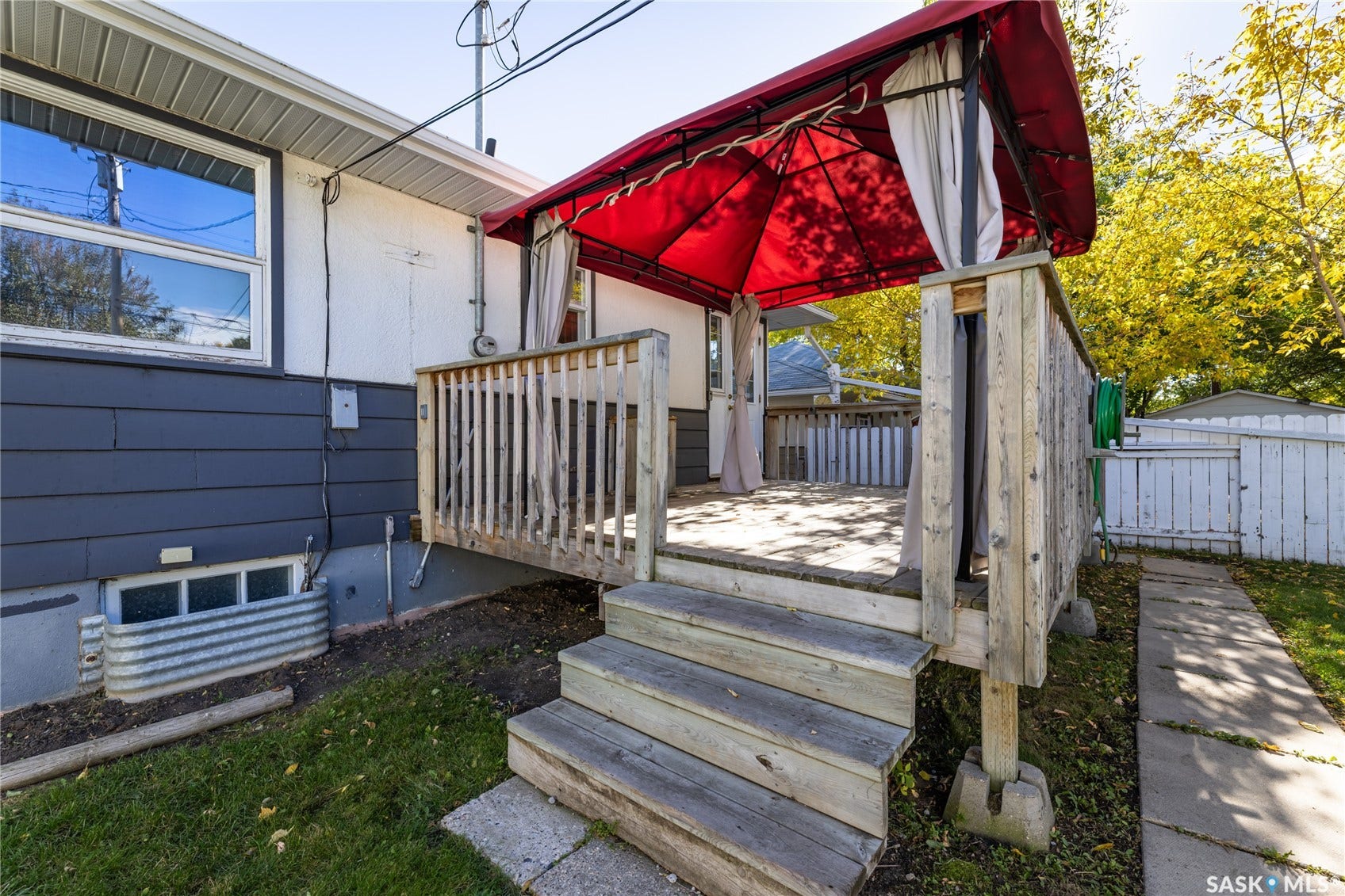 Wood deck with steps, red canopy, and white privacy curtains