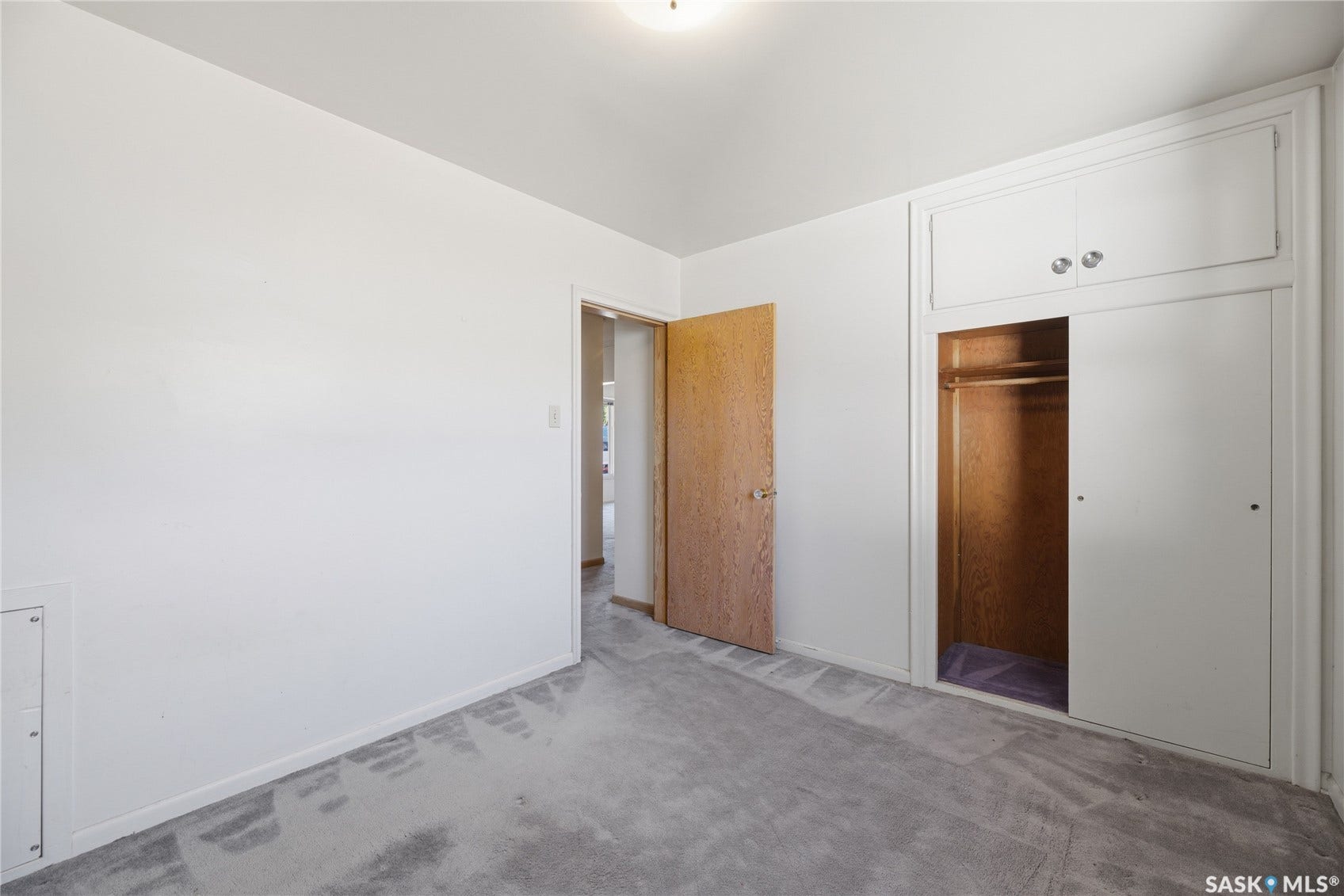 Built-in closet system with sliding doors and upper cabinetry
