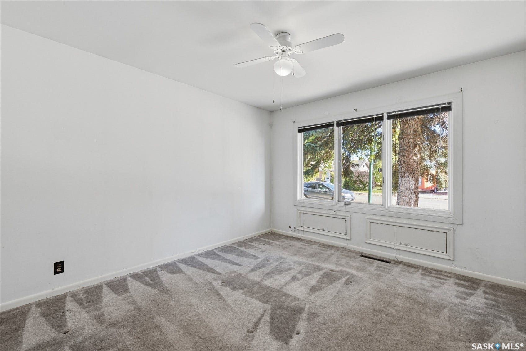 Ceiling fan, three large window panes, and wall-to-wall carpeting
