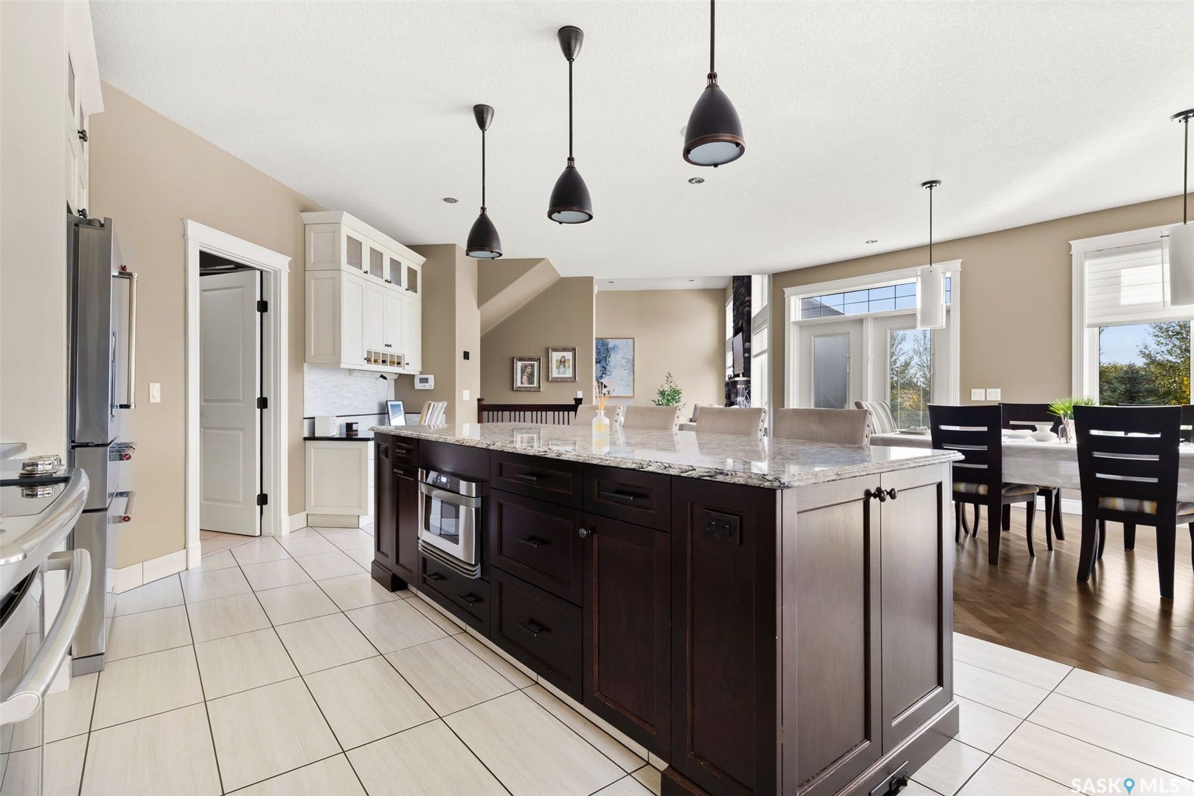 Expansive kitchen featuring a large island with integrated microwave, granite countertop, and pendant lighting