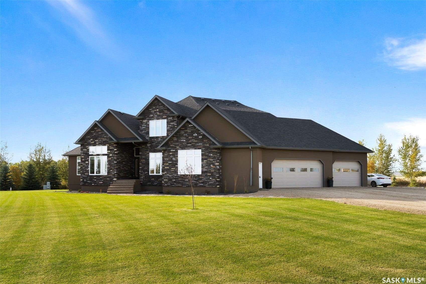Exterior featuring stone accents, stucco siding, and a multi-car garage