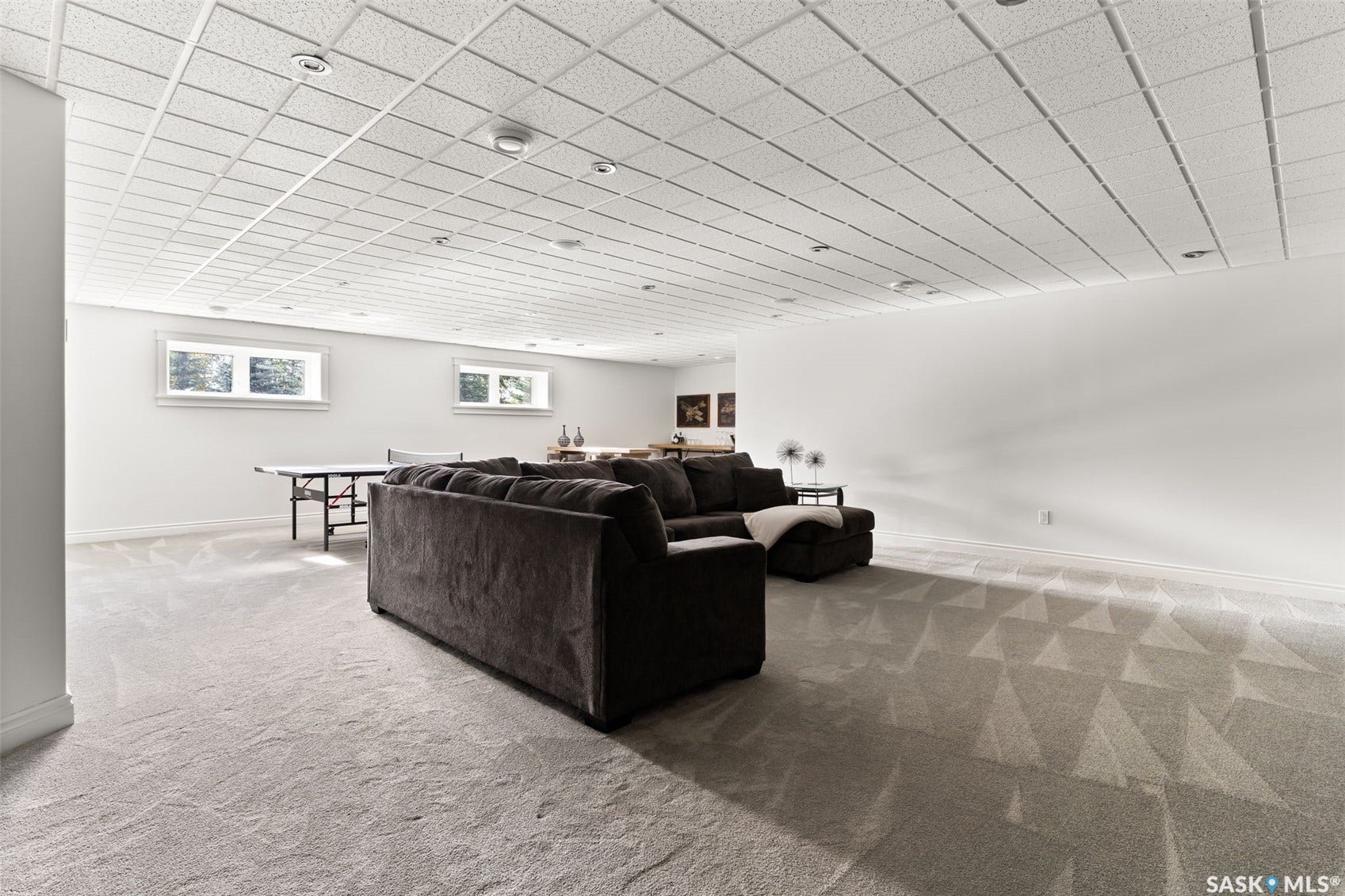 Expansive finished space featuring a drop ceiling, recessed lighting, wall-to-wall carpeting, and multiple windows
