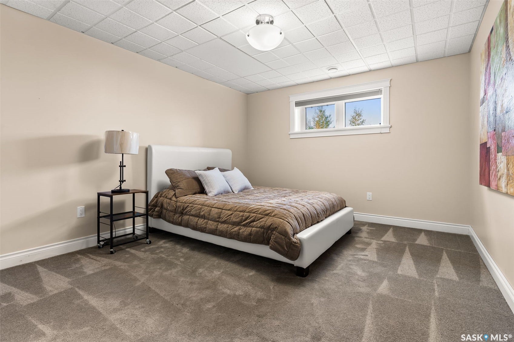 Recessed window with white trim, light-toned walls, and grey patterned carpet flooring