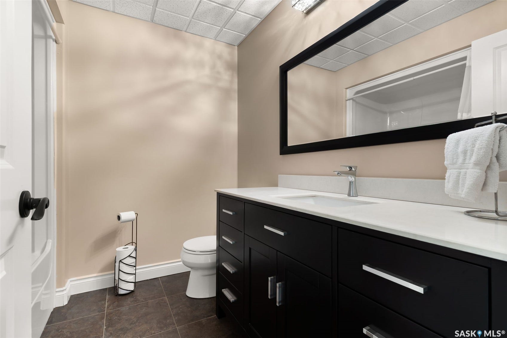 Dark wood-finish vanity with a white countertop and integrated sink
