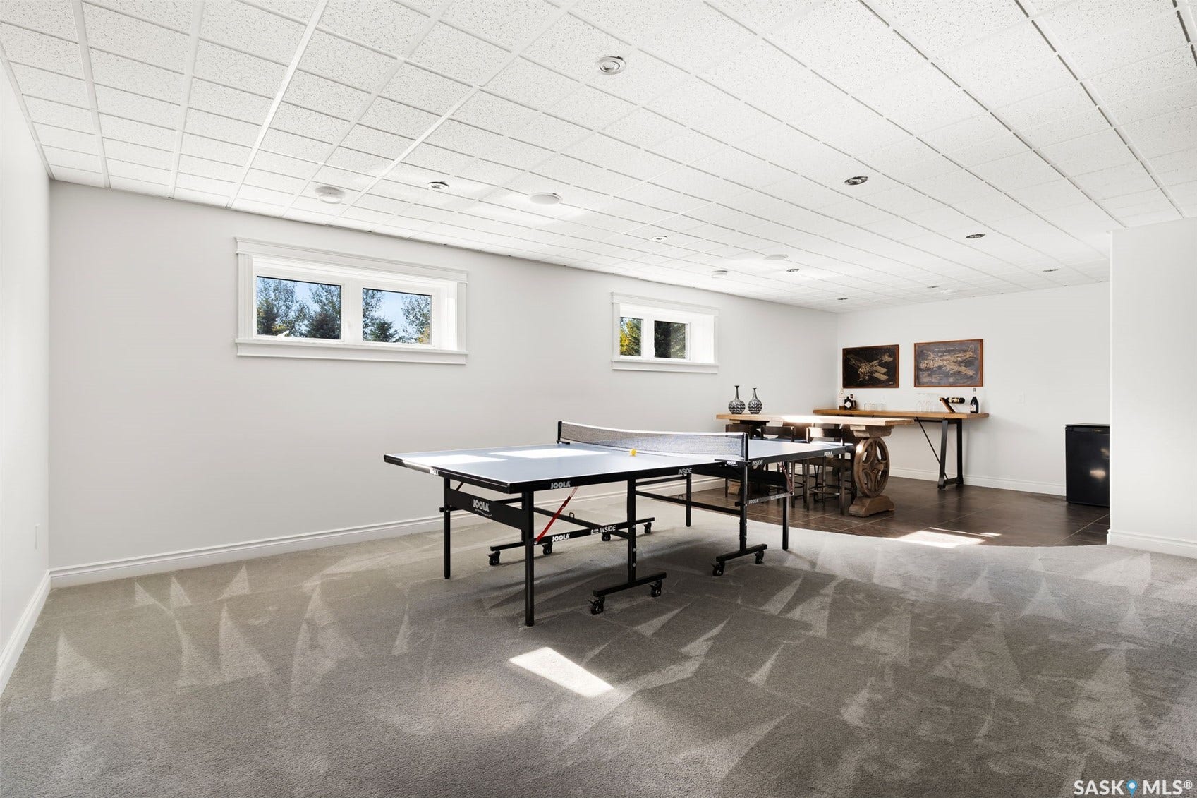 Recessed lighting, drop ceiling, and light gray patterned carpeting