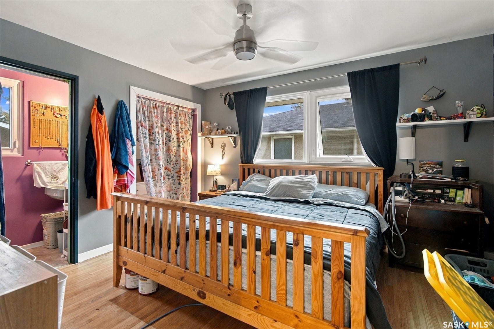 Wood-finish flooring throughout, ceiling fan, and two windows