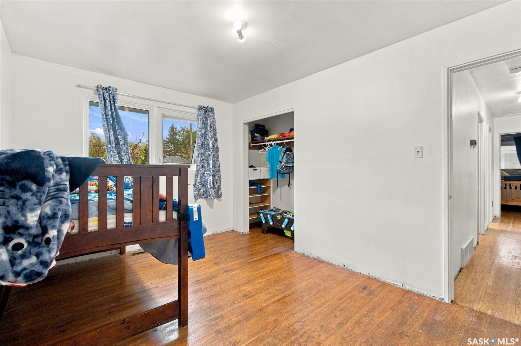 Wood-finish flooring, two large windows, recessed closet, white walls, and overhead lighting