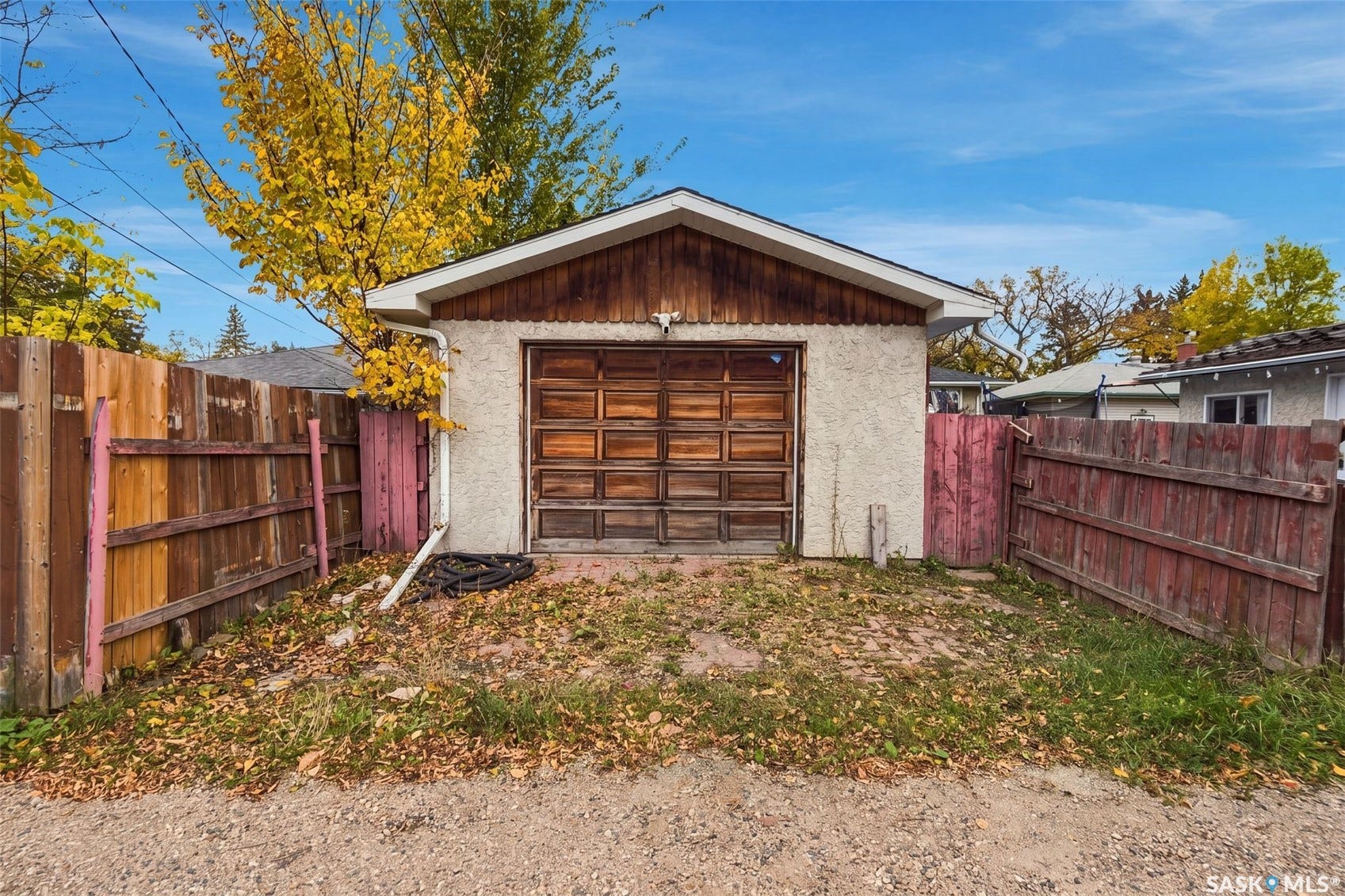 Detached garage with stucco exterior and wood-paneled door