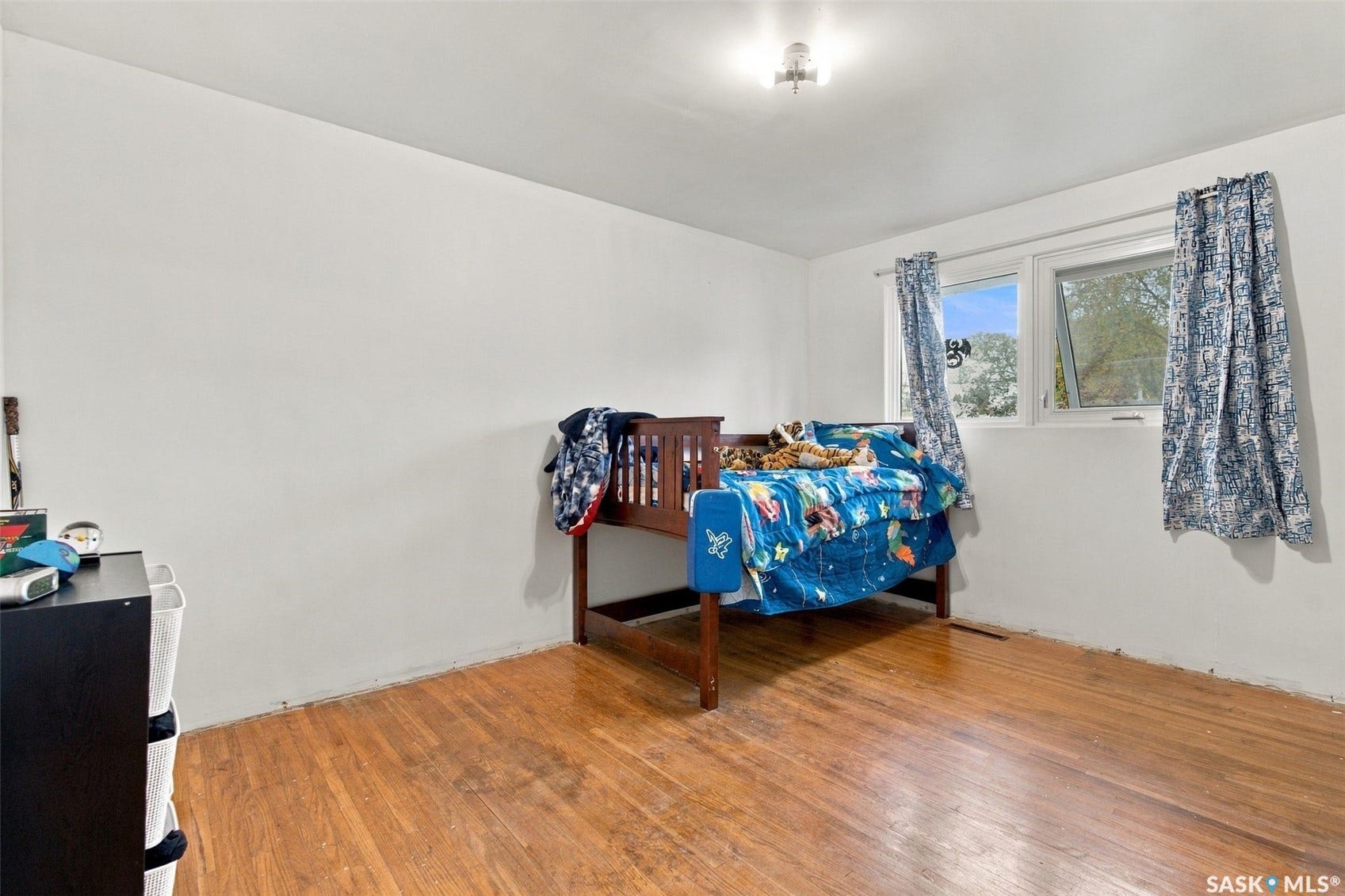 Wood-finish flooring, white walls, and a ceiling-mounted light fixture