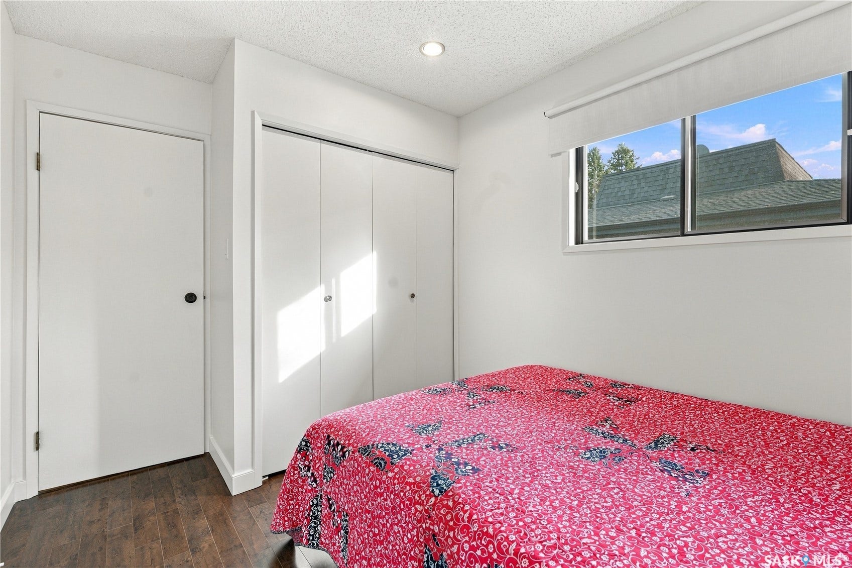 Wood-finish flooring, recessed lighting, and a window with roller shade