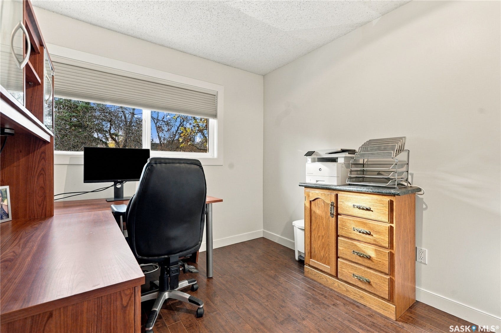 Wood-finish flooring, white walls, and a window with blinds