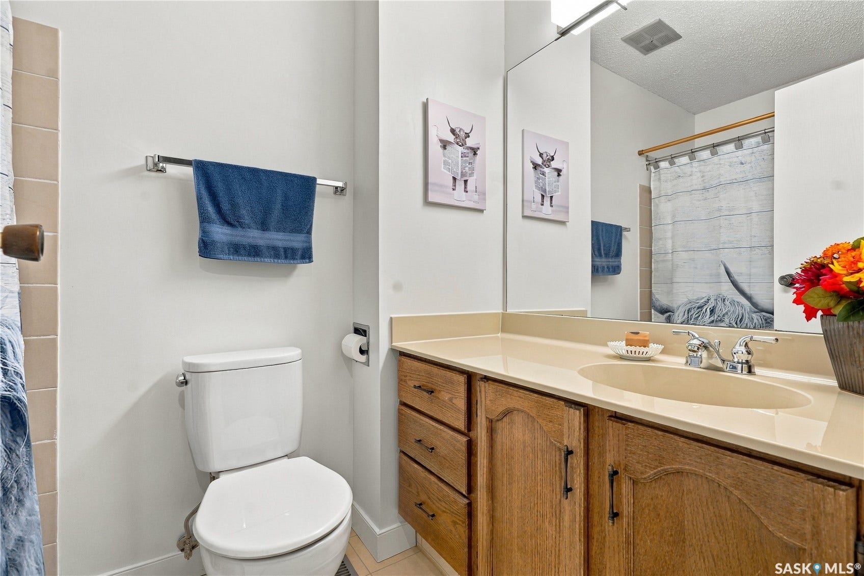 Bathroom featuring a wood-finish vanity with an integrated sink and a large mirror